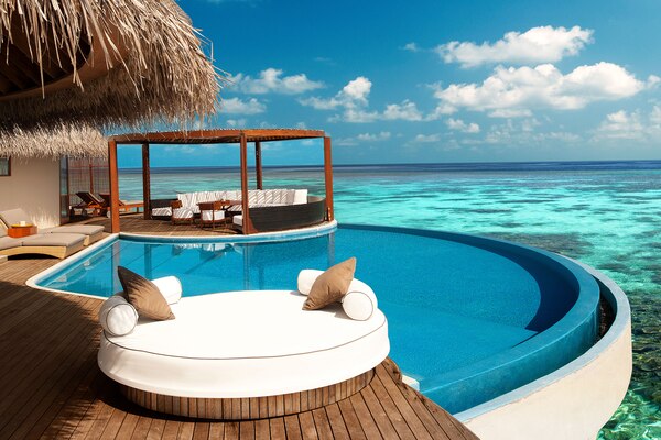 A wood hut with a pool overlooking the ocean